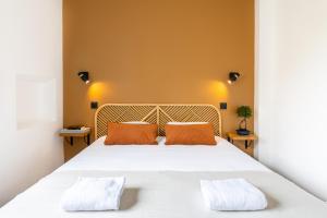 雷恩LIK APPARTS Thabor的卧室配有一张带两个橙色枕头的大白色床