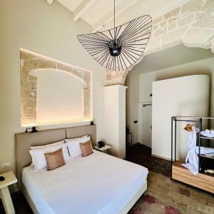 塔兰托Palazzo Matà Boutique Hotel的一间卧室配有一张床和一个吊灯