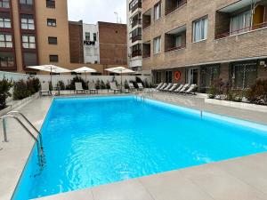 马德里JUAN BRAVO Apartamento a estrenar con PISCINA的大楼前的大型蓝色游泳池