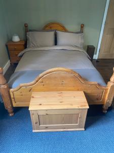 伦敦Tranquil Garden View Double Room的一张木床,配有木脚板和一张桌子