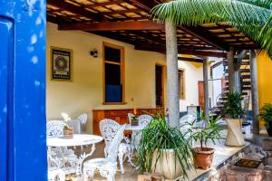 伦索伊斯Pousada Solar Azul的庭院配有白色的桌椅和植物