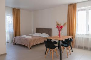 文尼察TREND HOUSE Apartments & Hostel的一间卧室配有一张床和一张桌子及椅子