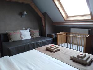佐内贝克't Hooghe Licht Bed & Breakfast的一间卧室配有一张床和一张带毛巾的婴儿床。
