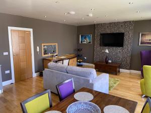 卡斯尔敦Halvard Apartments at Castletown的带沙发和电视的客厅