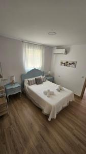 桑蒂蓬塞Apartamento Adriano的卧室配有一张白色的大床,铺有木地板