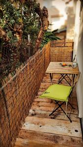 布德瓦Bonaca Apartments的木甲板上的一张桌子和一把绿色椅子