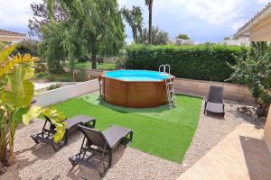 穆罗海滩Casa Ca Na Coloma 145 by Mallorca Charme的后院设有热水浴池和带椅子的草坪。
