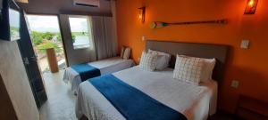 São FranciscoPousada Carapeba的酒店客房设有两张床和窗户。