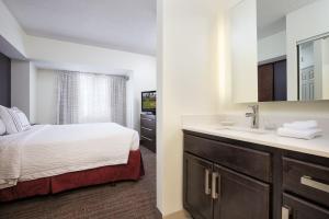 明尼阿波利斯明尼阿波利斯市中心旅行者酒店的客房内的浴室设有床和水槽
