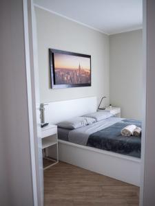 米兰SKYLINE MILANO Fiera的卧室配有一张床,墙上挂着一幅画