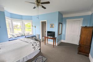 GeorgetownThe Georgetown Inn的一间卧室设有蓝色的墙壁、一张床和吊扇。