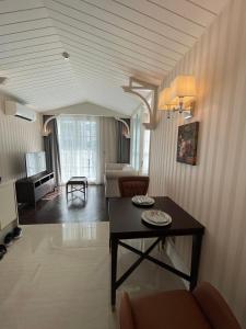 纳仲天Grand Florida BeachFront Resort NaJomtien Pattaya的客厅配有桌子和沙发