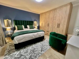 约翰内斯堡435 on vale boutique aparthotel的一间卧室设有一张大床和绿色床头板