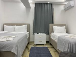 伊斯坦布尔Amida Family pansiyon的一间卧室设有两张床和窗户。