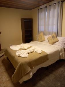 蒙特韦尔迪Pousada serrano的一间卧室配有带毛巾的床