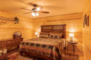 佩森Cabin #6 Bobcat Bunkhouse - Pet Friendly - King Bed - Sleeps 4的一间卧室配有一张床和吊扇