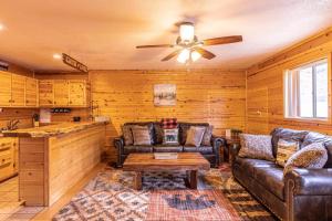 佩森Cabin #6 Bobcat Bunkhouse - Pet Friendly - King Bed - Sleeps 4的客厅配有皮革家具和吊扇