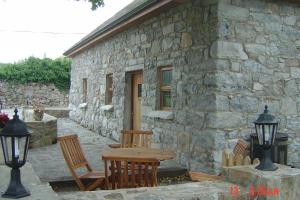 戈尔韦Traditional Stone Cottage 300 years+的石头建筑外的桌椅