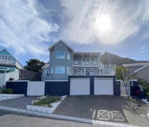 豪特湾Villa Amanzi的带阳台和车库的蓝色房屋