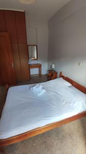 GialiskariNiko's Apartments A1的一张带白色床单的床和两张毛巾