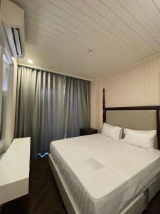 纳仲天Grand Florida BeachFront Resort NaJomtien Pattaya的卧室设有一张白色大床和一扇窗户。