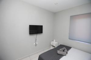 卡瓦拉iLposto Up的白色的客房配有床和平面电视。