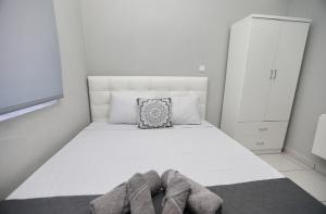卡瓦拉iLposto Up的卧室配有白色的床和鞋