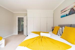 沃特福德Spacious Home- Great transport links and location- Families- contractors- professionals的一间卧室配有一张带黄色枕头的大床