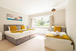 沃特福德Spacious Home- Great transport links and location- Families- contractors- professionals的一间卧室设有两张床和窗户。