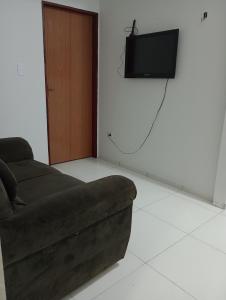 因佩拉特里斯Apartamento Mobiliado no Centro da Cidade的客厅配有沙发和墙上的电视