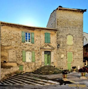 昂迪兹La tour de Pezene的一座古老的石头建筑,设有绿色的门和楼梯