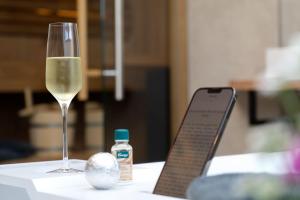 卡罗利嫩西尔施卢伊斯特公园酒店的一杯白葡萄酒,旁边放一瓶药