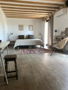滨海阿热莱斯La Casa Del Racou的卧室配有1张床、1张桌子和1把椅子