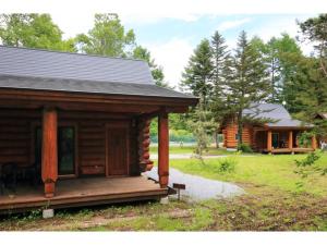 轻井泽Karuizawa Sunny Village - Vacation STAY 57947v的小木屋设有门廊和房屋