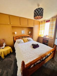 罗塞斯Park Road Holiday Home的一间卧室配有一张大床和木制床头板