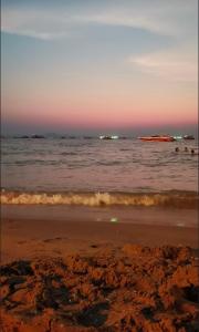 纳仲天Grand Florida BeachFront Resort NaJomtien Pattaya的日落时分欣赏海景