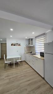 桑蒂蓬塞Apartamento Trajano的白色的厨房配有桌子和桌椅