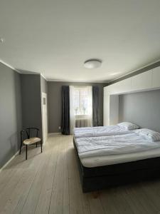 雷克桑德Fin lägenhet i centrala Leksand的一间卧室配有一张大床和一把椅子