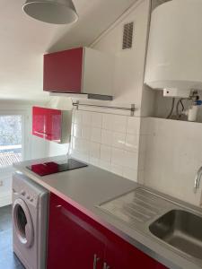 桑特Chez Emmanuel的一间带红色橱柜和洗衣机的厨房
