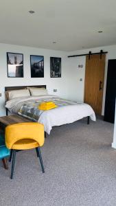 柯科迪Luxury beach front rooms- PMA的一间卧室配有一张大床和一张黄色椅子