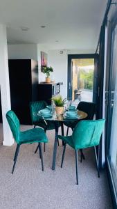 柯科迪Luxury beach front rooms- PMA的一间带桌子和绿色椅子的用餐室