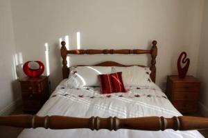 法尔卡拉Baile Go Deo.的一间卧室配有一张带红色枕头的木床。