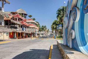 埃斯孔迪多港Villa Ocean的棕榈树和建筑的城镇里一条空的街道