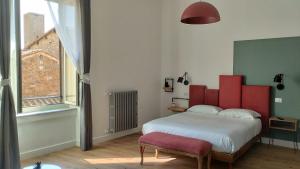 维泰博Ottantotto Viterbo的一间卧室设有一张大床和红色床头板