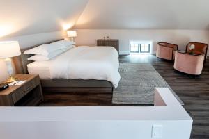 米西索加格瑞酒店的卧室配有一张白色的大床和一张桌子