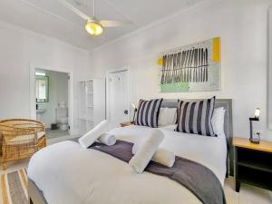 开普敦Exquisite and Homely Apartment, Private Balcony的卧室配有带条纹枕头的白色大床
