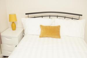 利兹Deluxe City Centre 4 Bedroom Entire Town House的一张白色的床,上面有黄色枕头