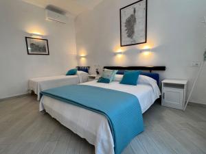 瓦达Casa Vanni的酒店客房 - 带两张带蓝色枕头的床
