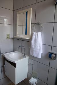 圣湖镇Casa com piscina e churrasqueira em Lagoa Santa MG的一间带水槽、镜子和毛巾的浴室