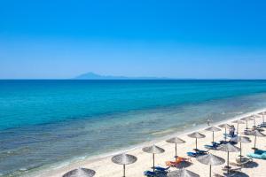 利迈纳里亚Boutique Giannikis By The Beach的海滩上一排与海洋相伴的遮阳伞
